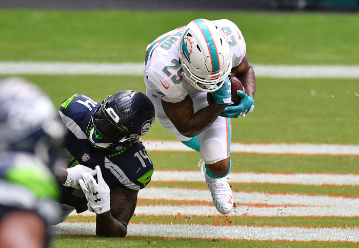 Xavien Howard goes to the ground as he secures an interception in front of Seahawks receiver DK Metcalf during a game in 2020